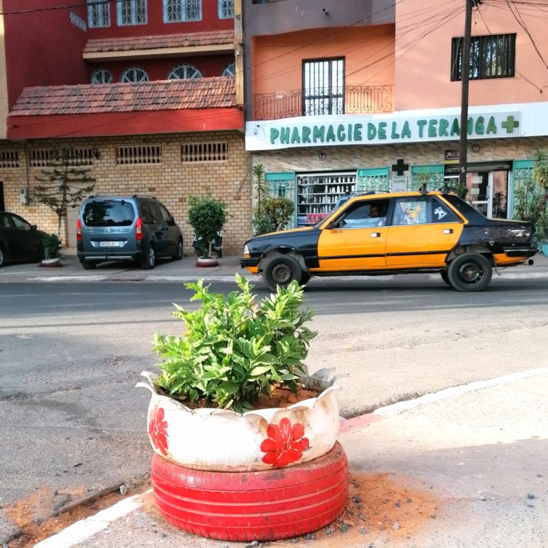 Un exemple du mot upcycling en montrant des pneus transformés en pot de fleurs au Sénégal